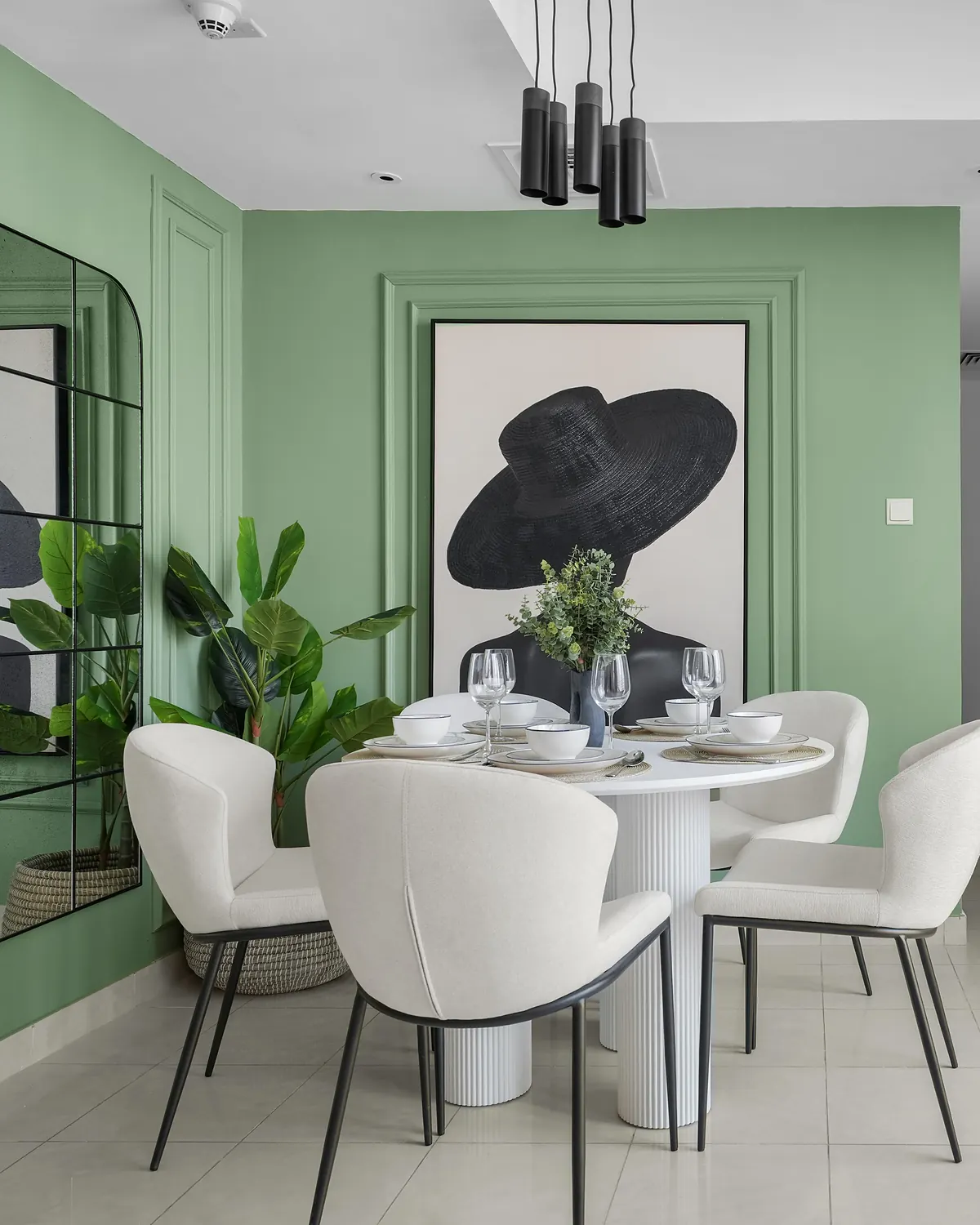 Dining corner with sage-green panel moulding, an arched mirror and a round table set for four